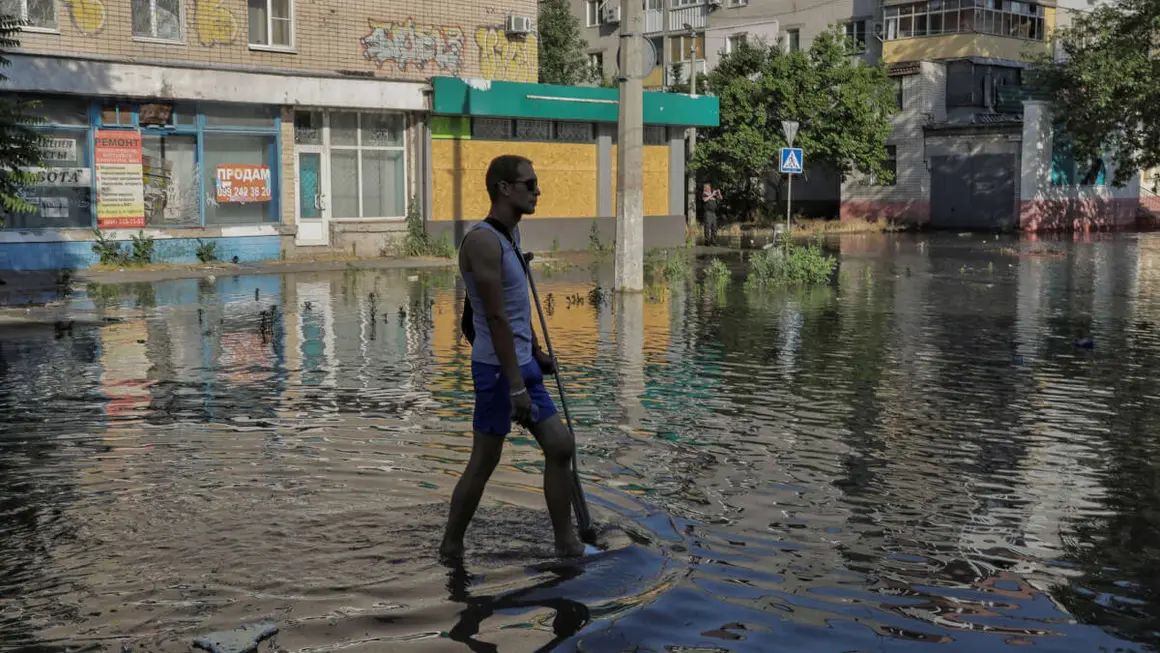 PHOTO/ REUTERS - Un residente local camina por una calle inundada tras la rotura de la presa de Nova Khakovka, en medio del ataque ruso a Ucrania, en la región de Kherson, Ucrania, 6 de junio de 2023