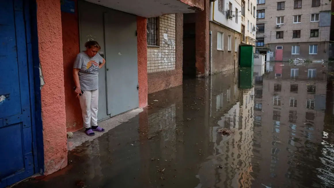 PHOTO/REUTERS - Olena junto a la entrada de su casa en una calle inundada, tras la rotura de la presa de Nova Kakhovka, en medio del ataque ruso a Ucrania, en la región de Kherson, Ucrania, 6 de junio de 2023