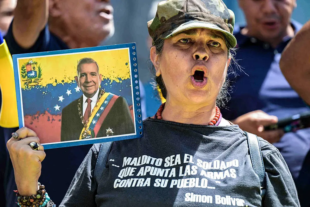 <p>Una partidaria del candidato presidencial opositor Edmundo González Urrutia y la líder opositora María Corina Machado gritan consignas durante una manifestación de protesta frente a la sede de las Naciones Unidas en Caracas el 30 de julio de 2024 - AFP/YURI CORTEZ</p>
