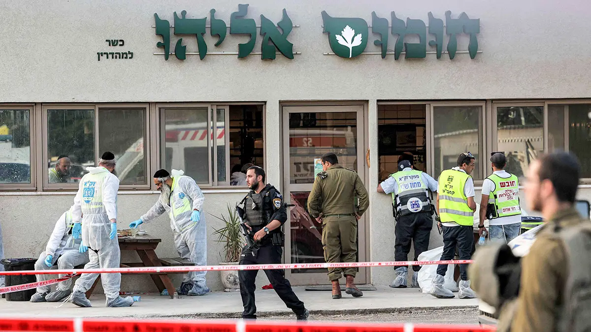 Israeli forensics experts inspect the scene of an attack outside a restaurant near the Jewish settlement of Eli in the north of the occupied West Bank on June 20, 2023. Four people were shot dead on June 20 near the settlement in the occupied West Bank, Israeli officials said, a day after an army raid left six Palestinians dead. (Photo by AHMAD GHARABLI / AFP)