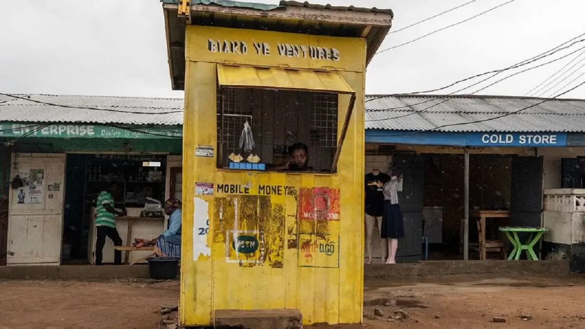 © FMI/Andrew Caballero-Reynolds - Una mujer mira la lluvia desde un puesto de cambio de dinero en Accra, Ghana