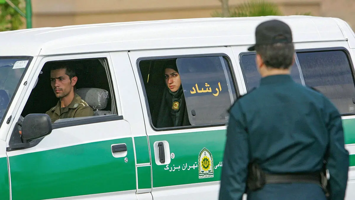 En esta foto de archivo tomada el 23 de julio de 2007, una mujer policía iraní observa desde la parte trasera de un vehículo policial antes del comienzo de una campaña para hacer cumplir el código de vestimenta islámico en la capital, Teherán
AFP/BEHROUZ MEHRI