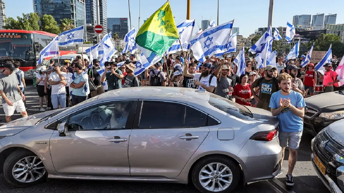 PHOTO/AFP/JACK GUEZ - Manifestantes marchan entre vehículos contra el plan de reforma judicial del Gobierno israelí durante una protesta masiva en Tel Aviv el 24 de julio de 2023