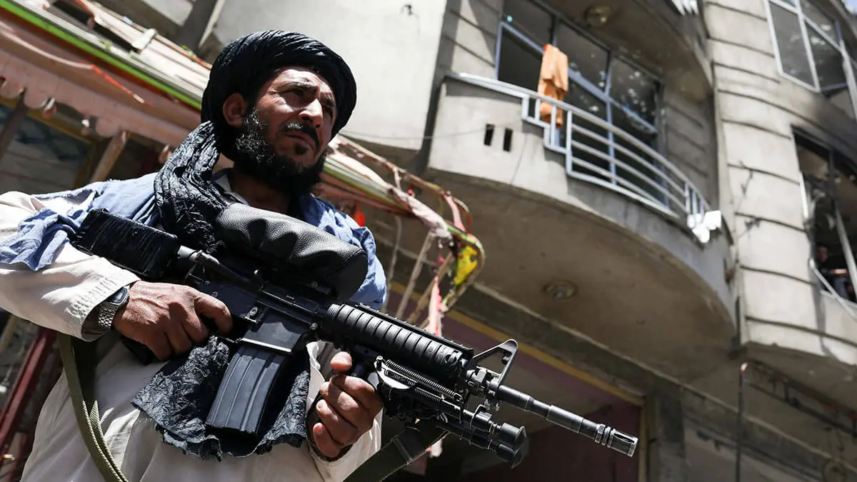 Un combatiente talibán hace guardia en el lugar donde un vehículo cargado de explosivos detonó en medio de un ataque a un templo sij en Kabul, Afganistán, el 18 de junio de 2022 - REUTERS/ALI KHARA