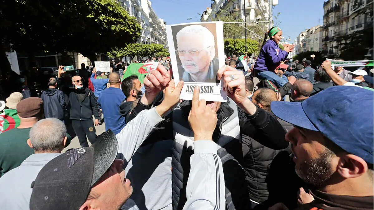 AP/TOUFIK DOUDOU - Fotografia de archivo, manifestantes señalan un retrato del ex ministro de Defensa argelino Khaled Nezzar durante una protesta en Argel, el viernes 12 de marzo de 2021