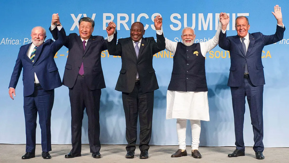 AFP/ALET PRETORIUS - De izquierda a derecha: el presidente de Brasil, Luiz Inácio Lula da Silva, el presidente de China, Xi Jinping, el presidente de Sudáfrica, Cyril Ramaphosa, el primer ministro de India, Narendra Modi, y el ministro de Asuntos Exteriores de Rusia, Sergei Lavrov, levantan los brazos mientras posan para una fotografía de grupo. , en la Cumbre BRICS en Johannesburgo el 23 de agosto de 2023