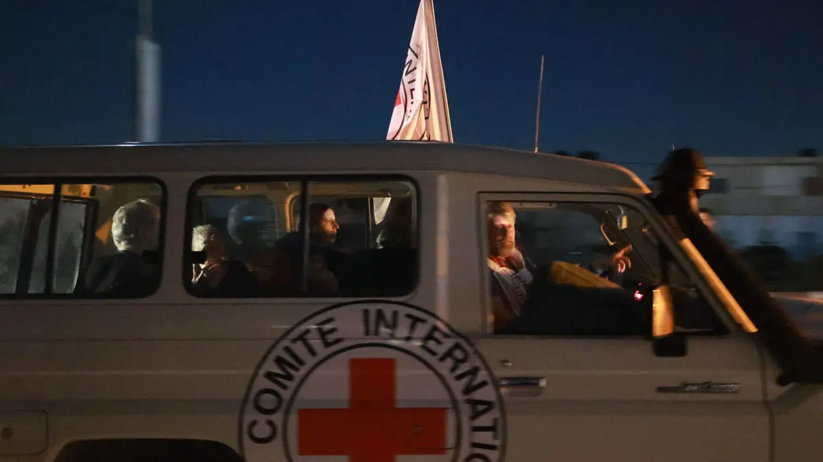 AFP/ MOHAMMED ABED - Un vehículo de la Cruz Roja Internacional con rehenes liberados por Hamás cruza el paso fronterizo de Rafah en la Franja de Gaza hacia Egipto