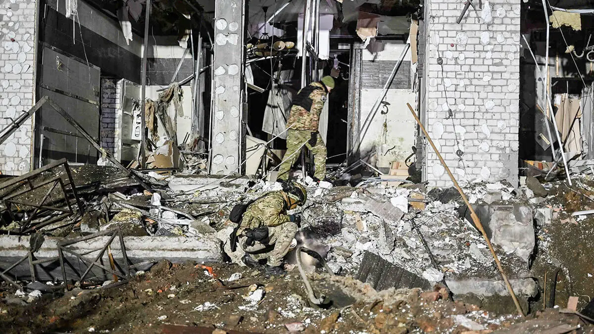 Expertos en explosivos militares ucranianos examinan el sitio de un hotel destruido tras un ataque con misiles en Kharkiv, el 11 de enero de 2024, en medio de la invasión rusa de Ucrania - AFP/SERGEY BOBOK