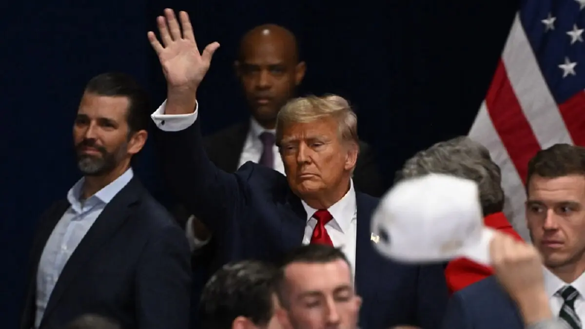 El expresidente estadounidense y aspirante presidencial republicano Donald Trump llega, con su hijo Donald (Izq), para hablar en una fiesta de observación durante los caucus presidenciales republicanos de Iowa 2024 en Des Moines, Iowa, el 15 de enero de 2024 - PHOTO/Jim WATSON/AFP