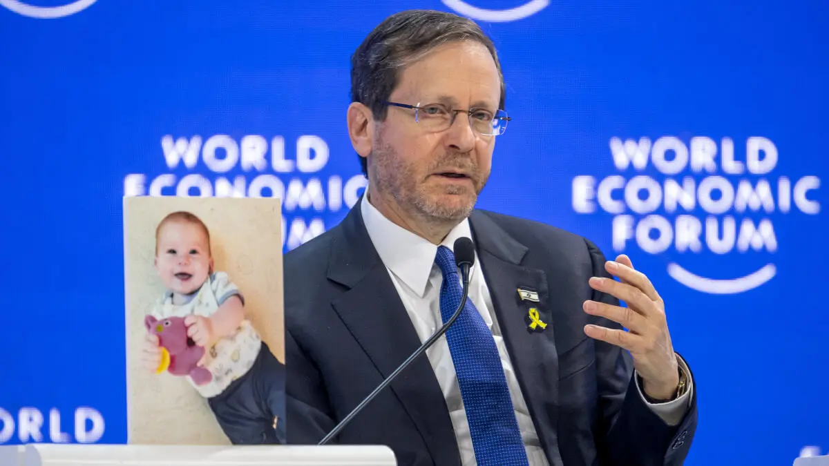 El presidente israelí, Isaac Herzog, muestra al bebé Kfir Bibas, retenido por Hamás, durante el Foro de Davos - Fabrice COFFRINI / AFP