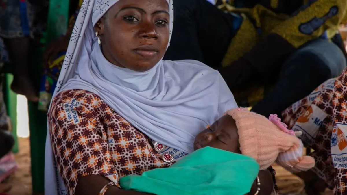 Una mujer con su bebé escucha al personal del UNFPA en una sesión de sensibilización sobre violencia de género en el One Stop Centre del hospital de Sominé Dolo - © UNFPA Mali/Amadou Maiga