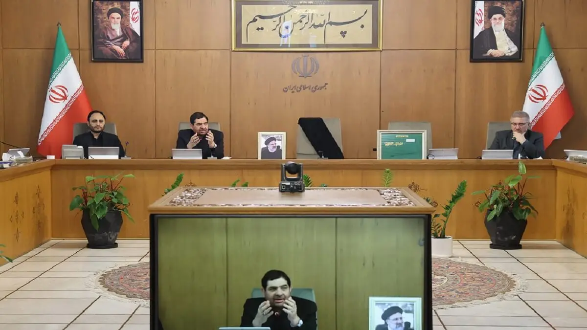 Una imagen difundida por la presidencia iraní muestra al primer vicepresidente de Irán, Mohammad Mokhber (pantalla frontal), con el asiento del difunto presidente Ebrahim Raisi (retrato) a su lado vacío (detrás), durante una reunión del gabinete en Teherán el 20 de mayo de 2024 – PHOTO/AFP PHOTO/HO/PRESIDENCIA IRANÍ