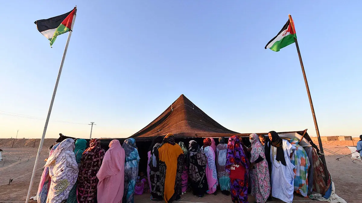 Mujeres saharauis se reúnen frente a una tienda de campaña durante el festival internacional de cine FiSahra, el 13 de octubre de 2022, en el campamento de refugiados de Aousserd, a las afueras de la ciudad de Tinduf, en el suroeste de Argelia - Fotografía de Ryad KRAMDI/AFP