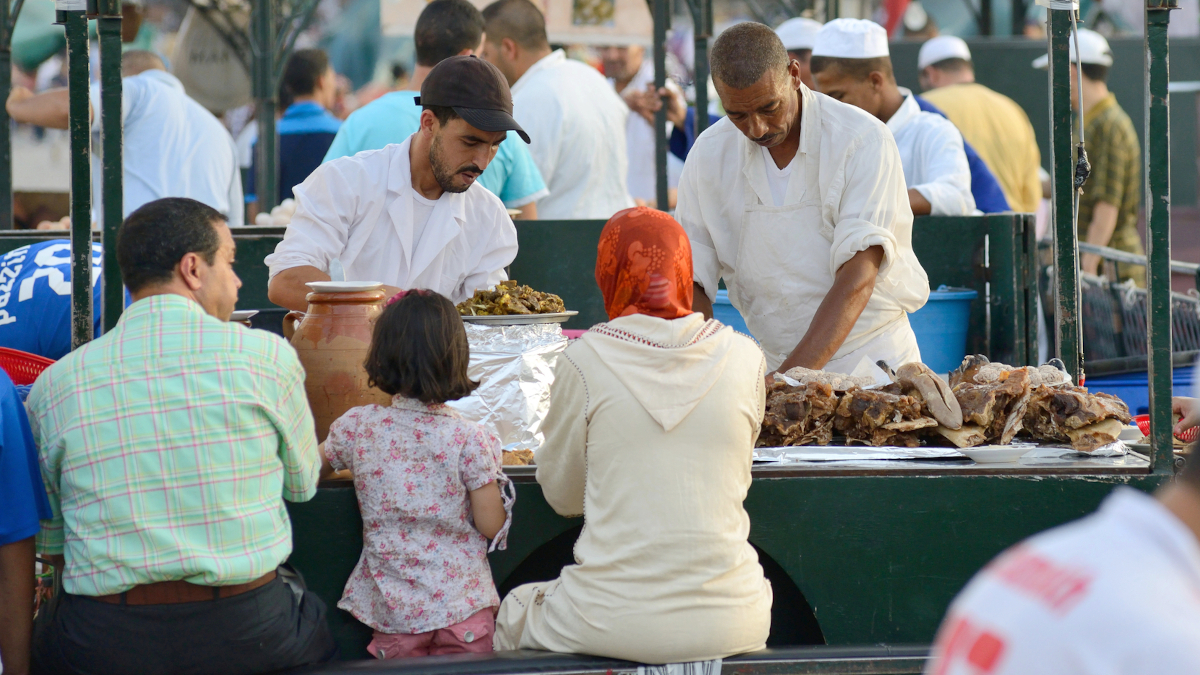 Familia marroquí disfrutando de uno de los puestos de comida de la plaza de Yamaa el Fna, Marrakech - <a href="https://depositphotos.com/es/?/">Depositphotos</a>