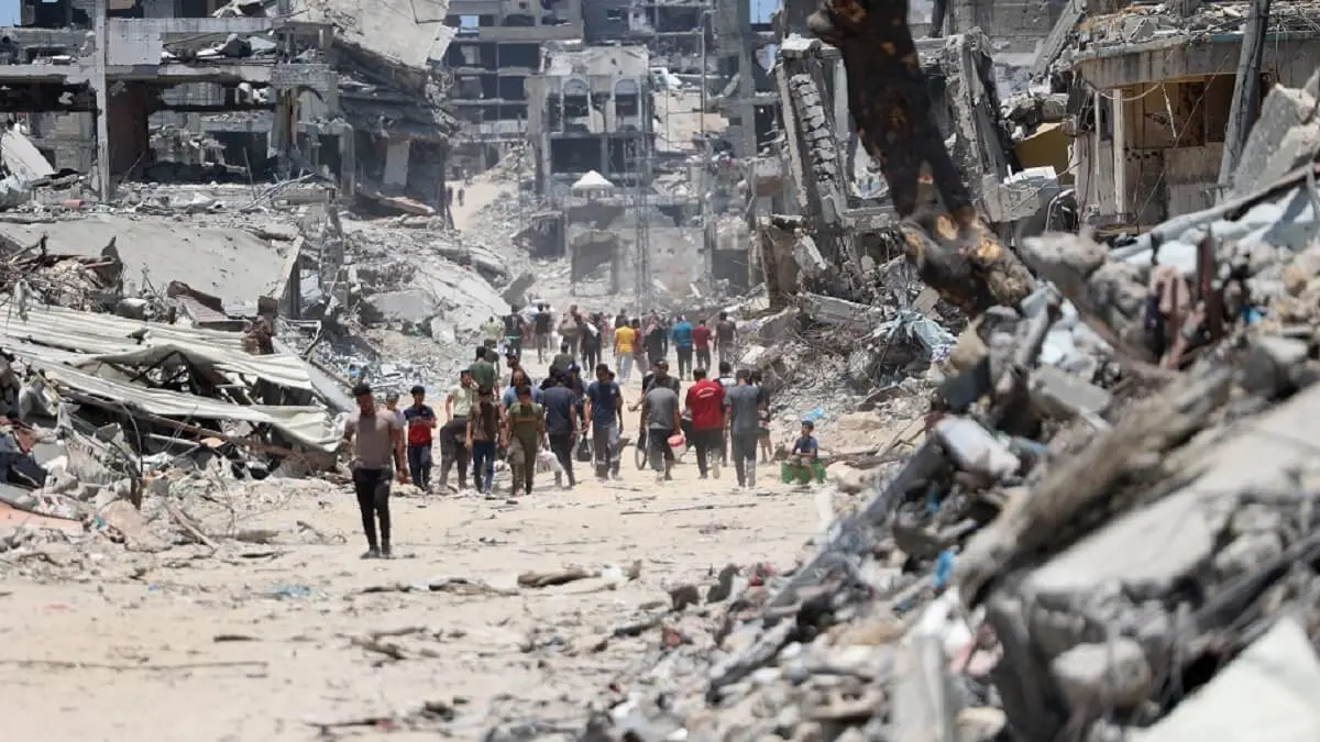 El 11 de julio de 2024, palestinos se abren paso entre los escombros de edificios destruidos tras la retirada del Ejército israelí del barrio de Shujaiya, al este de la ciudad de Gaza, después de una ofensiva de dos semanas, en medio del actual conflicto entre Israel y el grupo militante Hamás – PHOTO/Omar AL-QATTAA/AFP