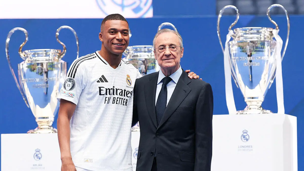 <p>El delantero francés Kylian Mbappé (izq.) posa con el presidente del Real Madrid, Florentino Pérez, durante su primera aparición como jugador del Real Madrid en el Estadio Santiago Bernabéu de Madrid el 16 de julio de 2024, tras firmar su nuevo contrato de cinco temporadas - AFP/PIERRE-PHILIPPE MARCOU </p>