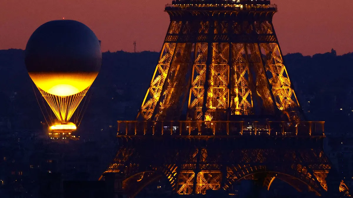 El pebetero olímpico y la Torre Eiffel tras la puesta del sol durante los Juegos Olímpicos - REUTERS/CHRISTIAN HARTMANN