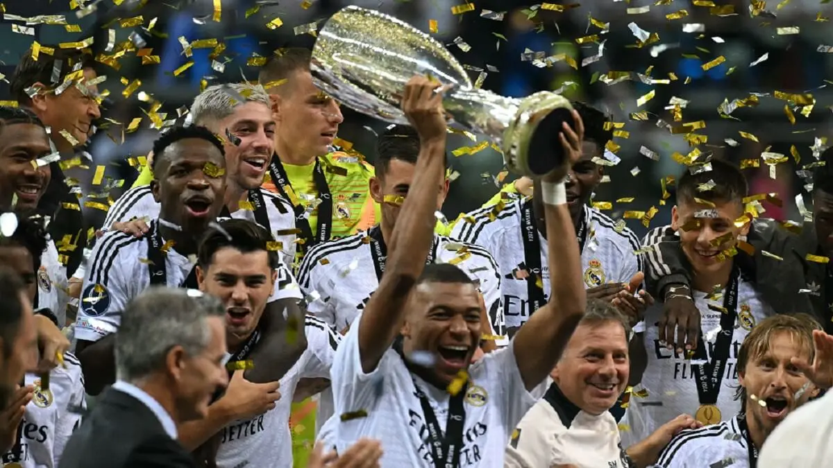 El delantero francés del Real Madrid Kylian Mbappe celebra con el trofeo tras el partido de fútbol de la Supercopa de la UEFA entre el Real Madrid y el Atalanta BC en Varsovia, el 14 de agosto de 2024 – PHOTO/Sergei GAPON/AFP