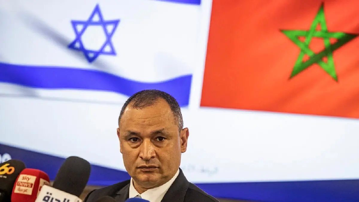 El ministro marroquí de Industria y Comercio, Ryad Mezzour, se dirige a los medios de comunicación bajo las banderas de su país y de Israel (izq.) tras su reunión con la ministra israelí de Economía, Orna Barbivai, en Rabat el 21 de febrero de 2022 – PHOTO/FADEL SENNA/AFP