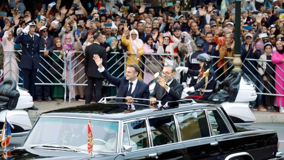 El rey de Marruecos, Mohamed VI, y el presidente de Francia, Emmanuel Macron saludan a la multitud mientras recorren una carretera de la capital, Rabat, el 28 de octubre de 2024 - PHOTO/ LUDOVIC MARIN / POOL / AFP