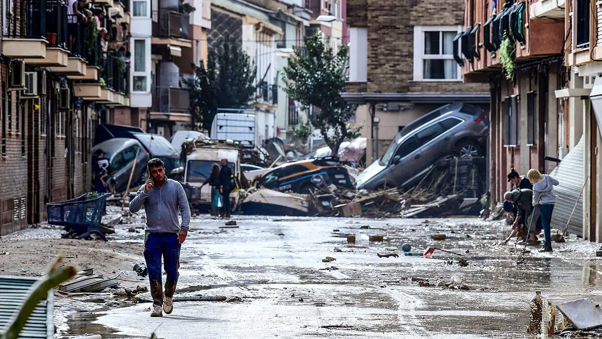 <p>Residentes junto a coches amontonados en una calle cubierta de barro tras las inundaciones en Picanya, cerca de Valencia, este de España, el 30 de octubre de 2024 - AFP/ JOSE JORDAN</p>
