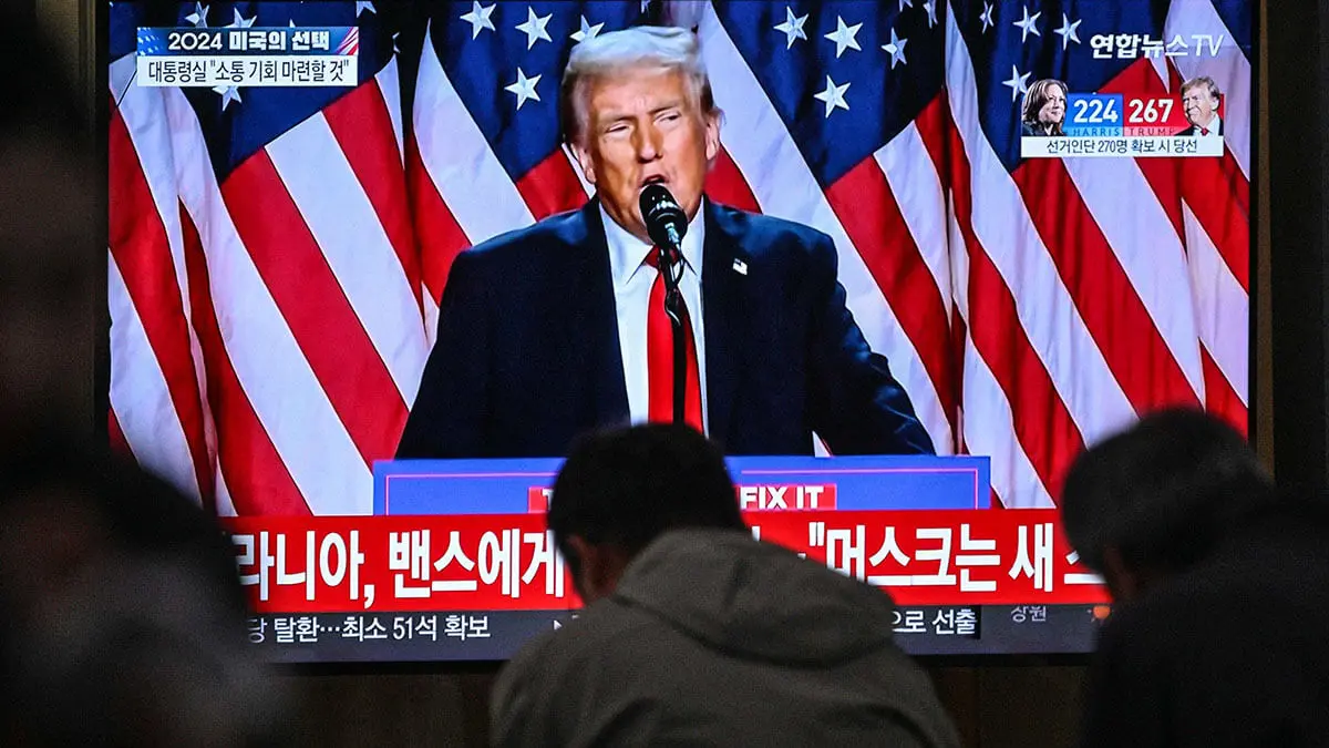 <p>Personas sentadas cerca de una transmisión de televisión que muestra al expresidente estadounidense y candidato presidencial republicano Donald Trump mientras habla durante un evento de la noche de las elecciones, en una estación de tren en Seúl el 6 de noviembre de 2024 - AFP/ANTHONY WALLACE&nbsp;</p>
