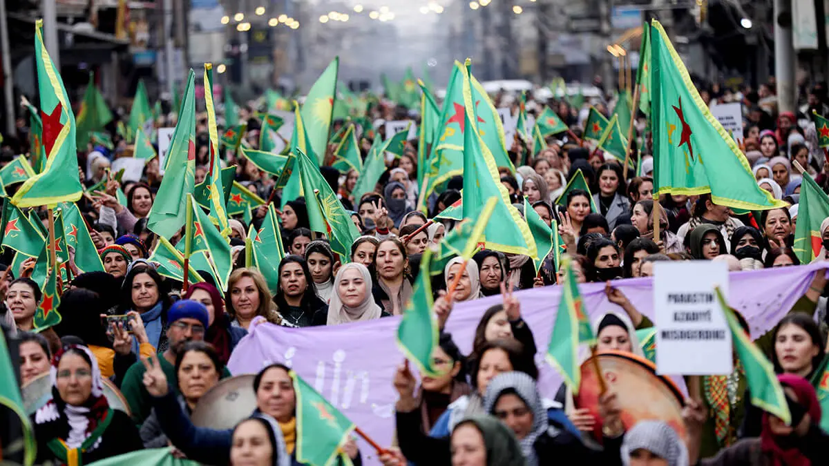 Mujeres sostienen banderas de las Unidades de Protección de la Mujer (YPJ) durante una manifestación para exigir a los nuevos gobernantes islamistas de Damasco que respeten los derechos de las mujeres y condenen las campañas militares apoyadas por Turquía en las regiones lideradas por los kurdos del norte, en la ciudad nororiental de Qamishli - REUTERS/ORHAN QUEREMAN