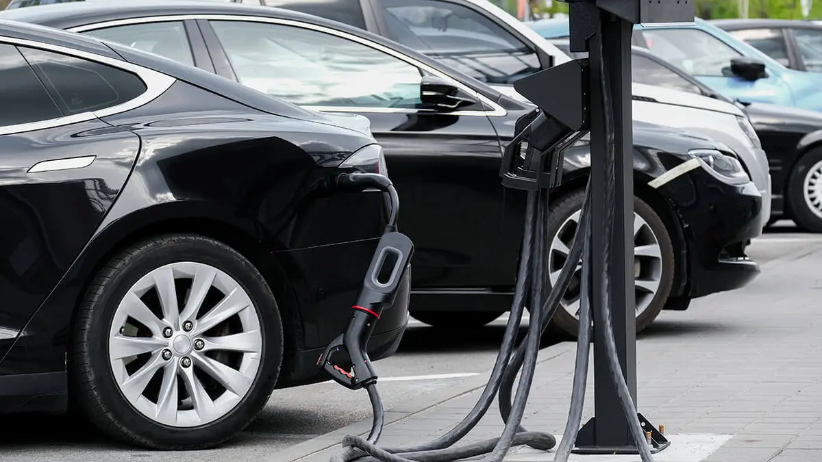 Vehículo eléctrico cagando baterías en un puesto de carga en la calle - <a href="https://depositphotos.com/es/?/">Depositphotos</a> 