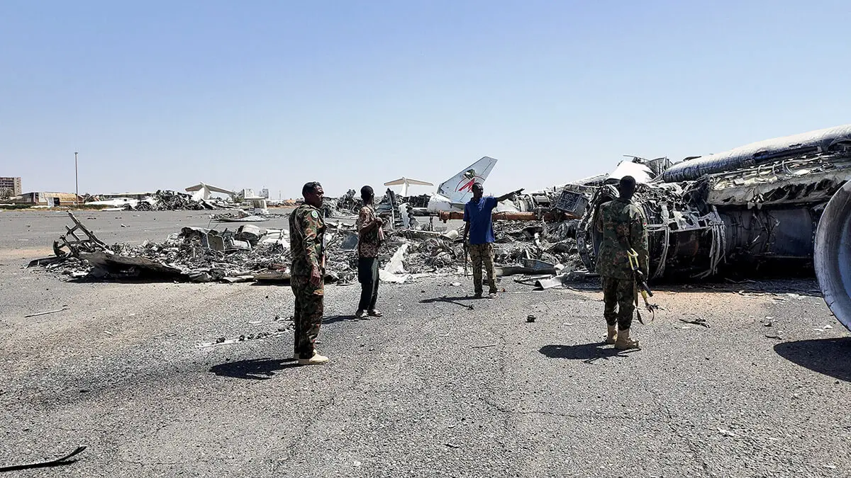 Miembros del Ejército sudanés caminan junto a los restos de un avión destruido en la pista del aeropuerto de Jartum, después de que el Ejército sudanés profundizara su control sobre la capital, Jartum, ante las Fuerzas de Apoyo Rápido, en Jartum, Sudán, el 27 de marzo de 2025 - REUTERS/EL TAYEB SIDDIG