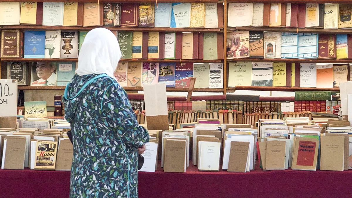 <p>Una lectora hojea libros en una librería de Rabat - PHOTO/ARCHIVO </p>