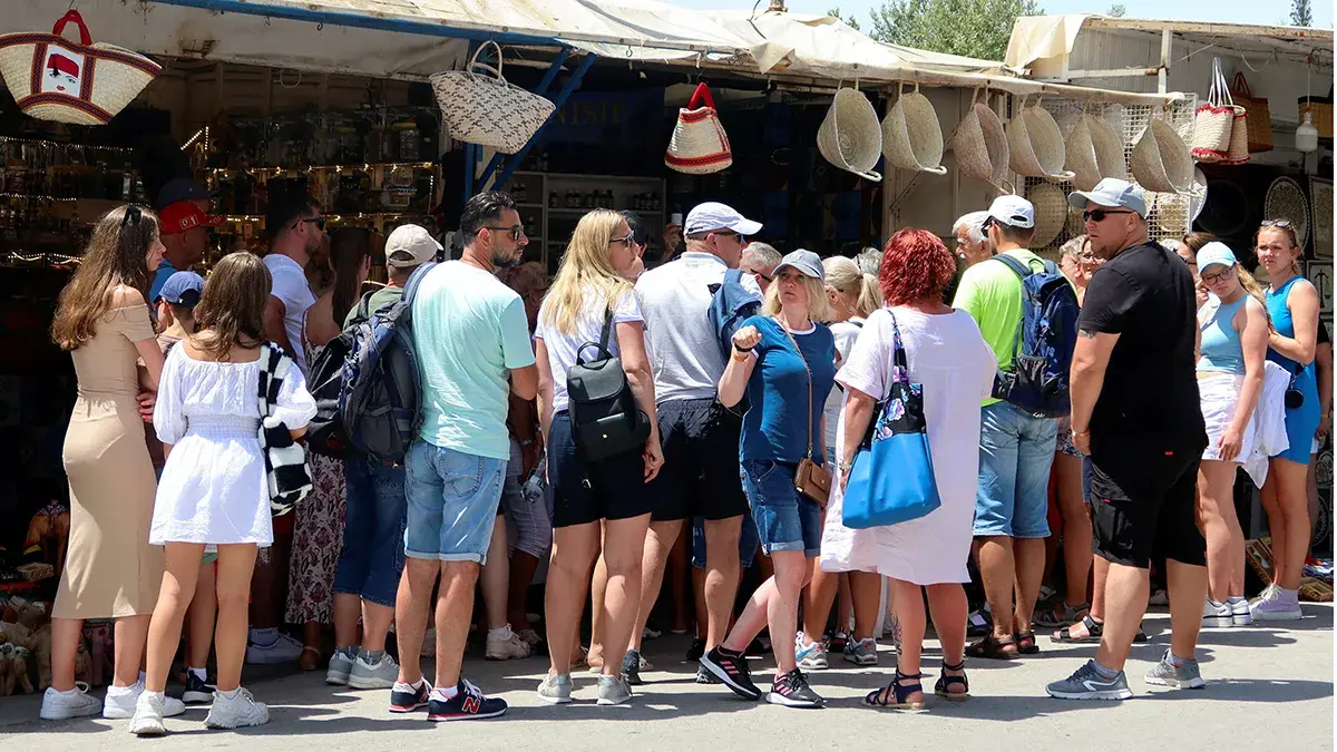 <p>Turistas cerca de tiendas de recuerdos en Sidi Bou Said, un popular destino tur&iacute;stico cerca de T&uacute;nez - REUTERS/ JHIHED ABIDELLAOUI</p>
