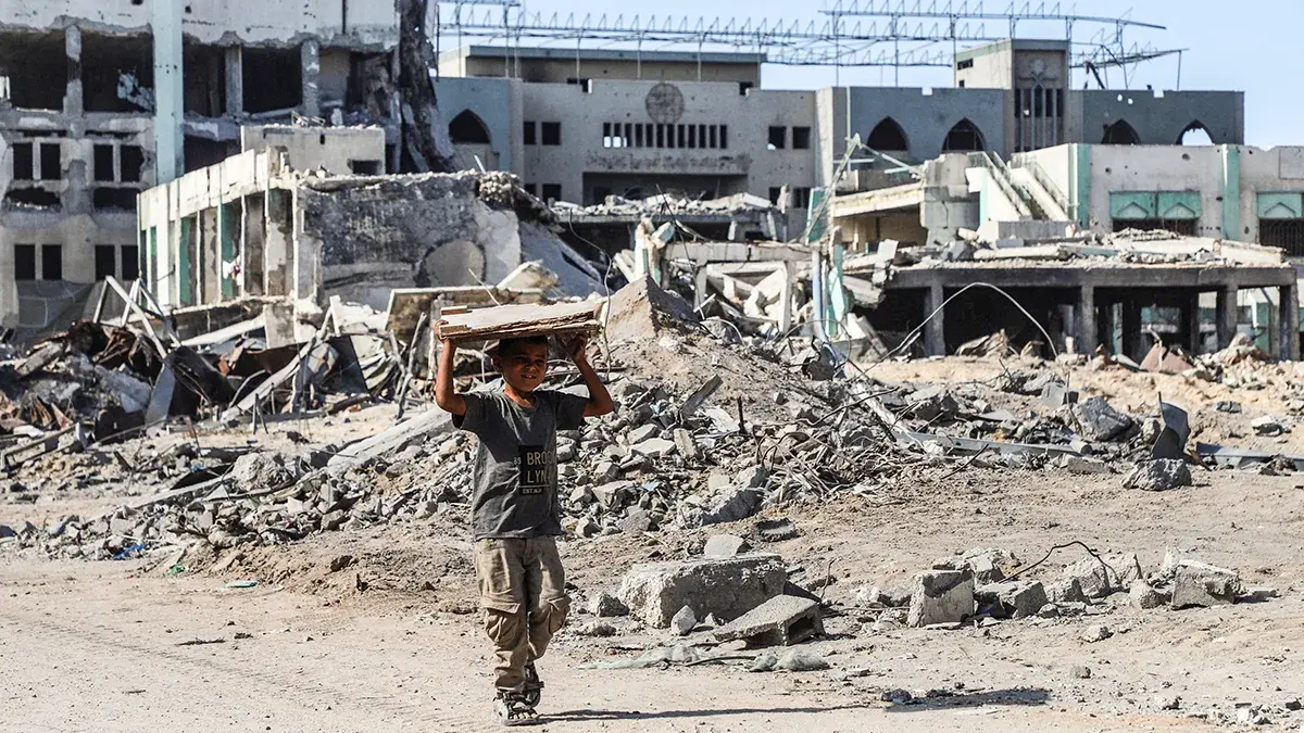 <p>Un ni&ntilde;o palestino camina con un trozo de madera en la mano, en medio de un alto el fuego entre Israel y Ham&aacute;s, en la ciudad de Gaza, el 16 de octubre de 2025 - REUTERS/ EBRAHIM HAJJAJ</p>
