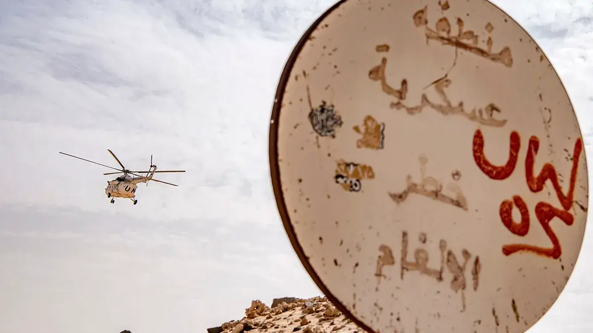 Una se&ntilde;al que indica un campo minado en una zona militar se muestra mientras un helic&oacute;ptero Mil Mi-8 de la Misi&oacute;n de las Naciones Unidas para el Refer&eacute;ndum del S&aacute;hara Occidental (MINURSO) sobrevuela el lado marroqu&iacute; del paso fronterizo entre Marruecos y Mauritania en Guerguerat, en el S&aacute;hara Occidental, el 25 de noviembre de 2020 - PHOTO/ ARCHIVO&nbsp;