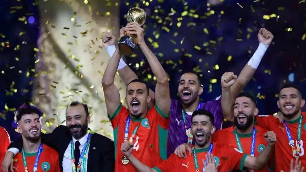 El marroqu&iacute; Soufiane Bouftini celebra en el podio junto a sus compa&ntilde;eros y el entrenador Tarik Sektioui tras ganar la Copa &Aacute;rabe de F&uacute;tbol en el estadio Lusail de Catar, el 18 de diciembre de 2025