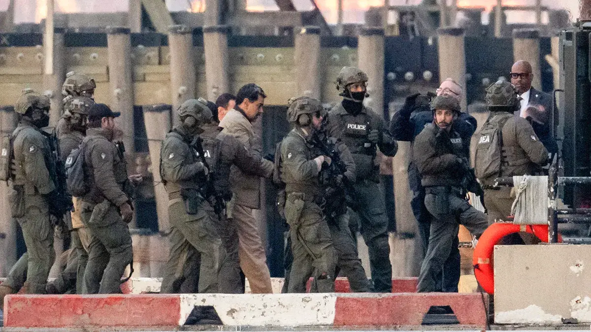 <p>El presidente venezolano Nicol&aacute;s Maduro, capturado, es escoltado mientras se dirige al juzgado federal Daniel Patrick Moynihan de Manhattan para comparecer por primera vez y enfrentarse a cargos federales estadounidenses, entre los que se incluyen narcoterrorismo, conspiraci&oacute;n, tr&aacute;fico de drogas, blanqueo de capitales y otros, en el helipuerto del centro de Manhattan, en la ciudad de Nueva York, Estados Unidos, el 5 de enero de 2026 - REUTERS/ ADAM GRAY&nbsp;</p>
