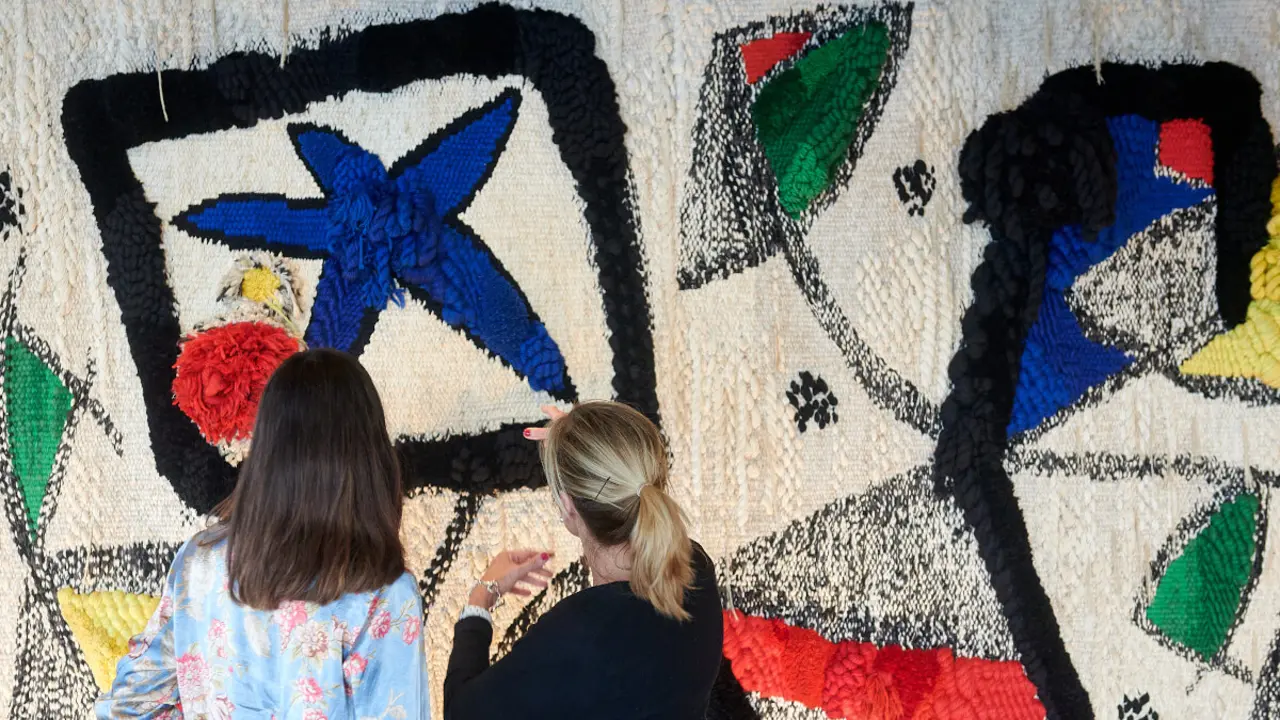 La estrella de Miró muestra el tapiz a los visitantes que llegan y se van del centro acompañado de plafones que cuentan la historia de la pieza