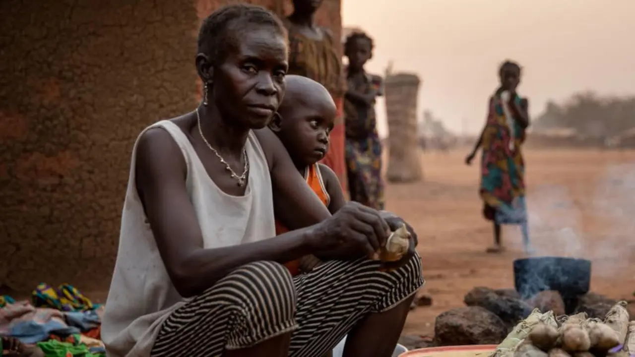 UNOCHA/Adrienne Surprenant - Una mujer desplazada internamente vende palitos de mandioca, el principal alimento básico en la República Centroafricana, en un sitio para personas desplazadas en Batangafo