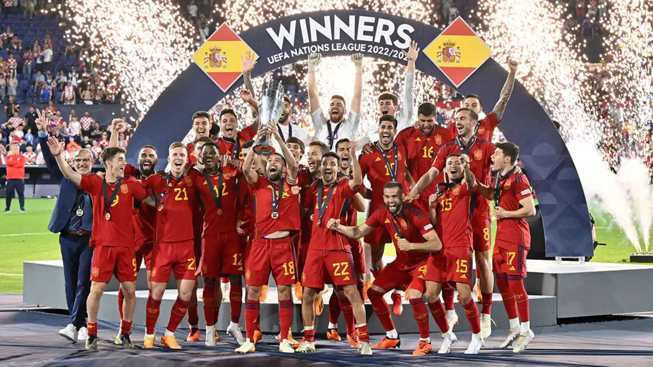 AFP/JOHN THYS - Los jugadores españoles celebran en el podio con la copa de la UEFA Nations League tras ganar la tanda de penaltis y la final entre Croacia y España en el De Kuip Stadium de Róterdam, el 18 de junio de 2023