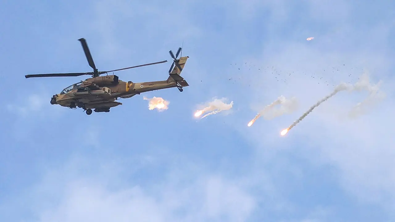 FOTO/AFP / Jaafar ASHTIYEH - Un helicóptero de ataque AH-64 Apache de la Fuerza Aérea Israelí libera una carga útil durante una incursión del ejército israelí en Jenin, en la Cisjordania ocupada, el 19 de junio de 2023. Violentos enfrentamientos estallaron en Jenin el 19 de junio durante una redada israelí en la ciudad de Cisjordania en la que el ejército disparó misiles desde un helicóptero, según un fotógrafo de la AFP en el lugar