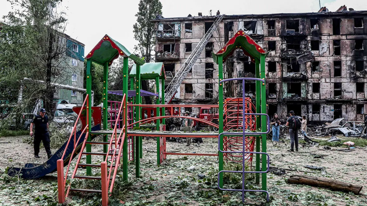 Parque infantil frente a un edificio residencial destruido tras un ataque ruso, en la ciudad de Kryvyi Rig el 13 de junio de 2023
AFP/STAS YURCHENKO