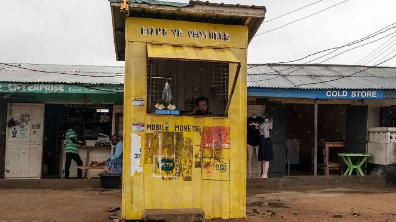 © FMI/Andrew Caballero-Reynolds - Una mujer mira la lluvia desde un puesto de cambio de dinero en Accra, Ghana