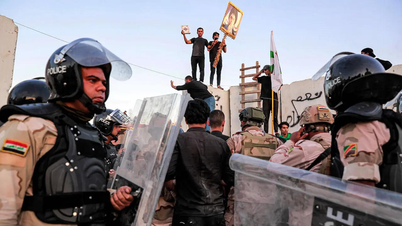 AFP/AHMAD AL-RUBAYE - La policía antidisturbios iraquí intenta dispersar a los partidarios del clérigo chiíta iraquí Moqtada al-Sadr reunidos para una protesta frente a la embajada sueca en Bagdad el 20 de julio de 2023