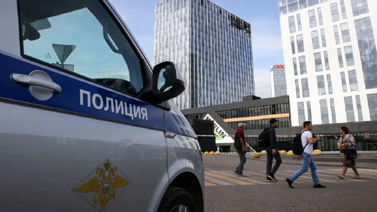 PHOTO/AFP/STRINGER - Un coche de policía se ve estacionado frente a un centro de negocios dañado en la calle Likhacheva después de un ataque con drones reportado en Moscú el 24 de julio de 2023