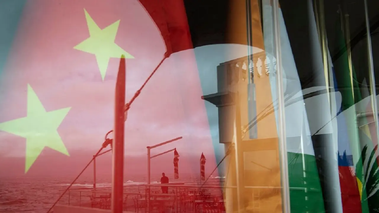 PHOTO/AFP/RODGER BOSCH - Vista del reflejo en una ventana de un hombre mirando al mar frente a las banderas nacionales de los países BRICS (China, India, Rusia, Sudáfrica y Brasil) durante la reunión de ministros de Asuntos Exteriores de los BRICS en Ciudad del Cabo, el 2 de junio de 2023