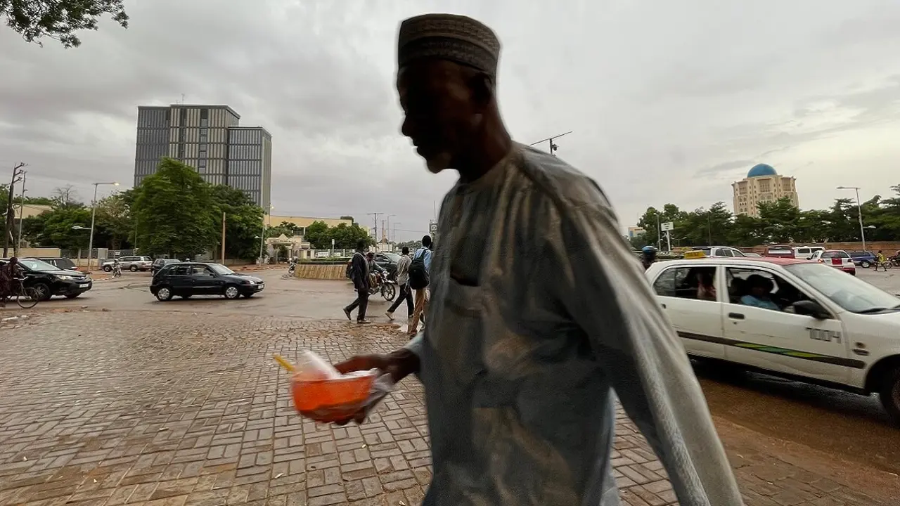 PHOTO/AFP - Un hombre camina por la acera en Niamey el 27 de julio de 2023 después de que el presidente de Níger, Mohamed Bazoum, fuera detenido por tropas de élite que declararon haber tomado el poder en la conflictiva nación de África occidental