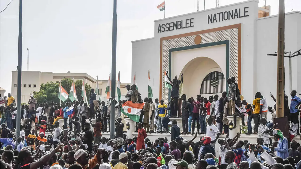 PHOTO/AFP - Partidarios ondean banderas de Níger mientras se reúnen en apoyo de la junta de Níger frente a la Asamblea Nacional en Niamey el 30 de julio de 2023