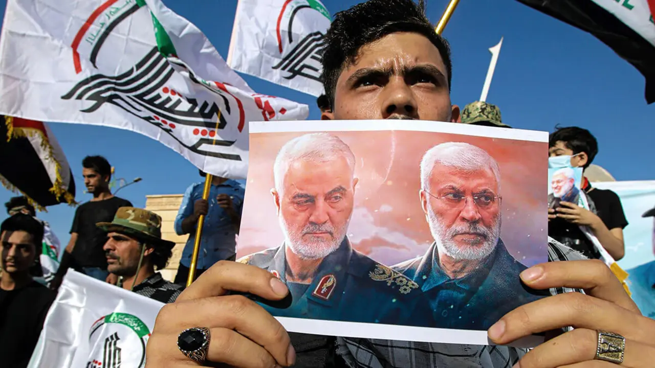 AP/ NABIL AL-JURANI - Un partidario de una milicia respaldada por Irán sostiene un cartel del general iraní Qassem Soleimani, subcomandante Abu Mahdi al-Muhandis durante una protesta de milicianos pro iraníes y sus partidarios para condenar los comentarios de un alto funcionario del gobierno kurdo que pide la destitución