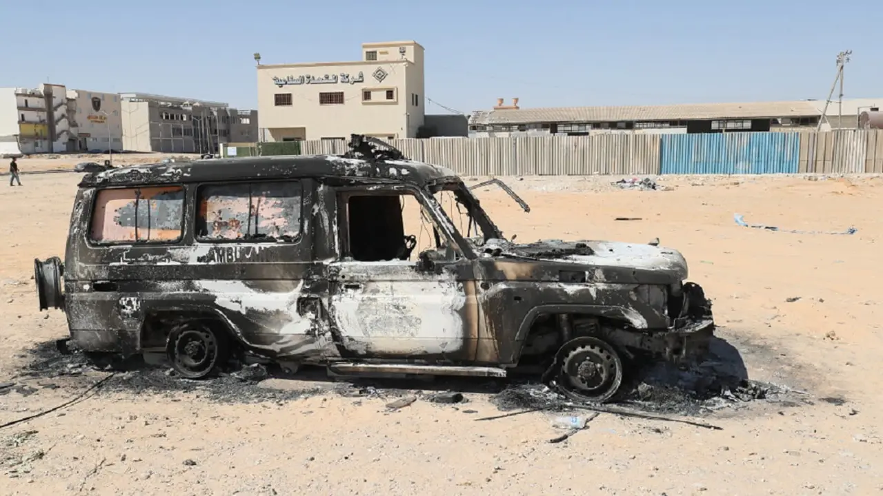 Imagen de un coche calcinado tras dos días de enfrentamientos entre dos grupos rivales en la capital de Libia, el 16 de agosto de 2023 - PHOTO/AFP/MAHMUD TURKIA