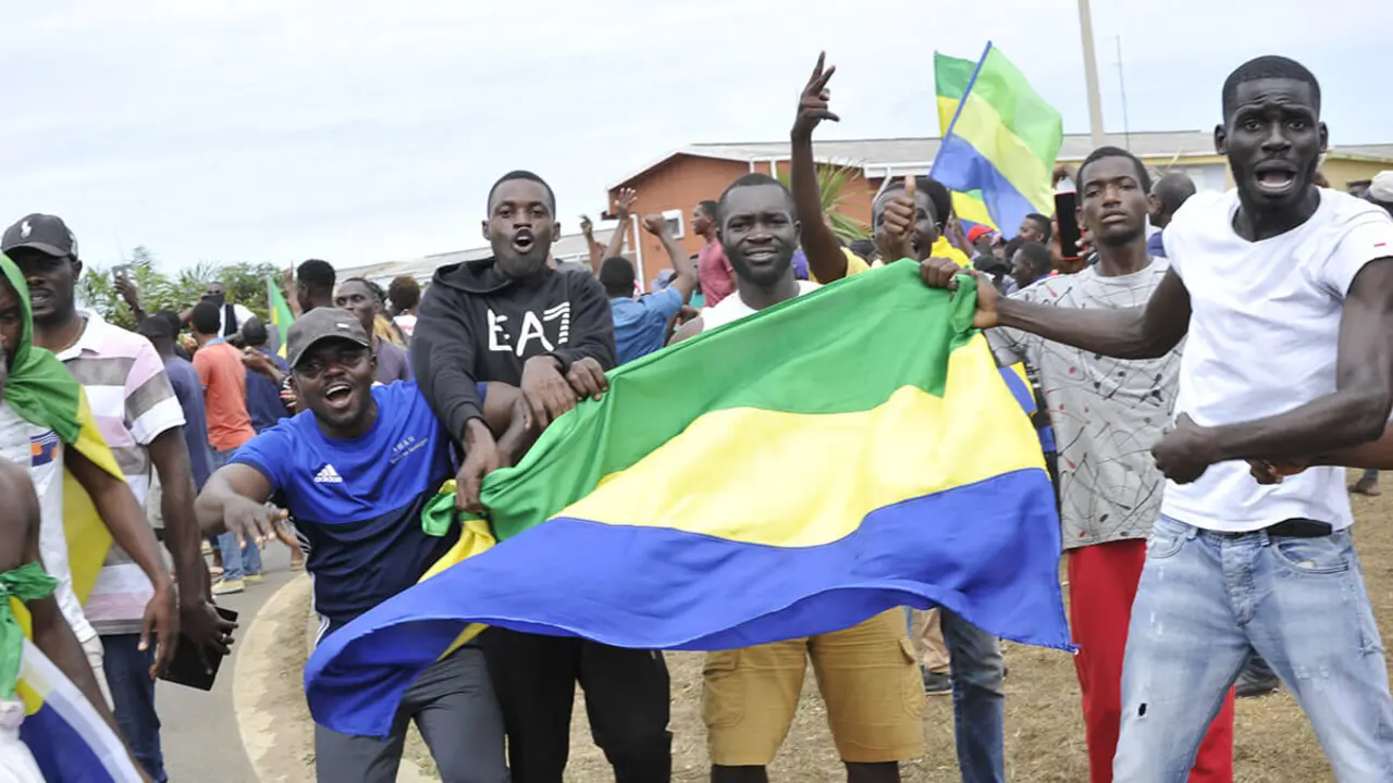 El 30 de agosto de 2023, los habitantes de Libreville celebran con banderas nacionales de Gabón después de que un grupo de oficiales militares gaboneses aparecieran en televisión anunciando que estaban "poniendo fin al régimen actual" y anulando los resultados oficiales de las elecciones que habían otorgado otro mandato al veterano presidente Ali Bongo Ondimba
PHOTO/AFP