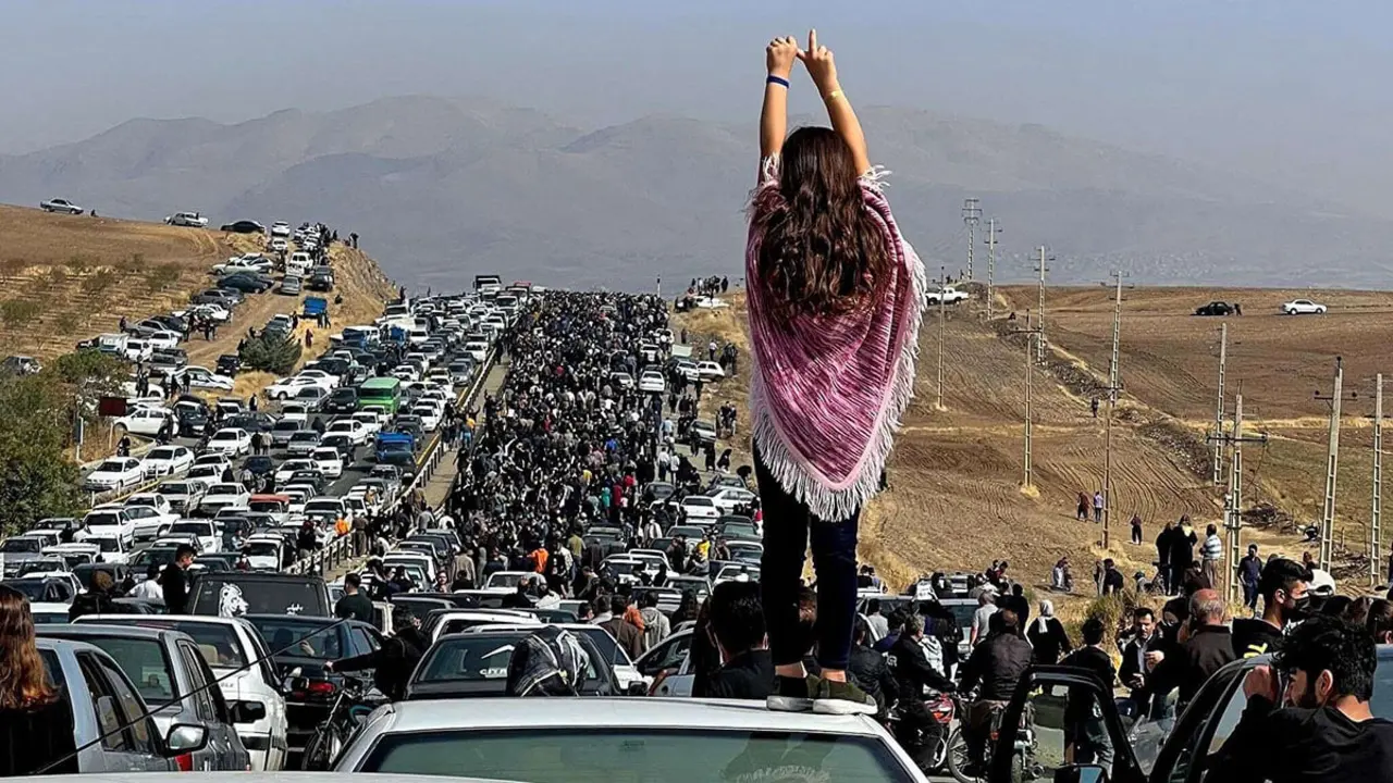 Pie de foto: Esta imagen de UGC publicada en Twitter el 26 de octubre de 2022 e muestra a una mujer sin velo parada encima de un vehículo mientras miles de personas se dirigen hacia el cementerio de Aichi en Saqez, la ciudad natal de Mahsa Aminis en la provincia occidental iraní de Kurdistán

PHOTO/ UGC
